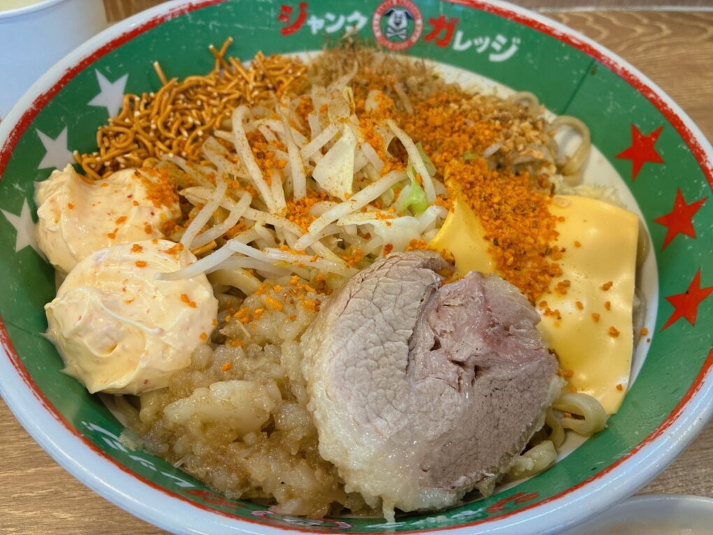 混ぜる前のパワフルまぜそば。アブラ、エビマヨ、チーズ、ベビースターなどが並びます。
