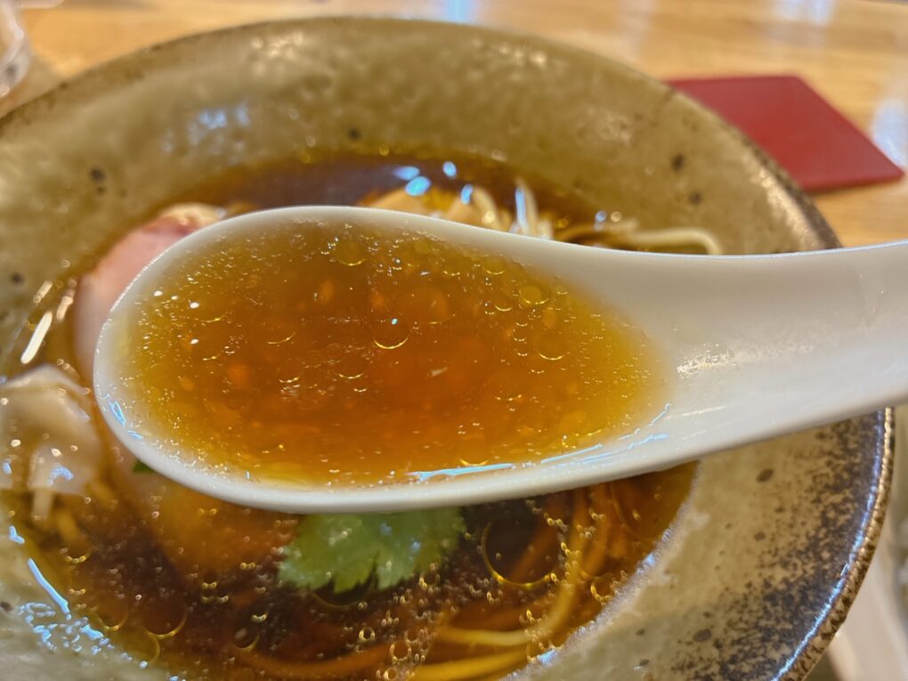 レンゲですくった醤油スープ。キリッとした醤油の旨みが印象的。