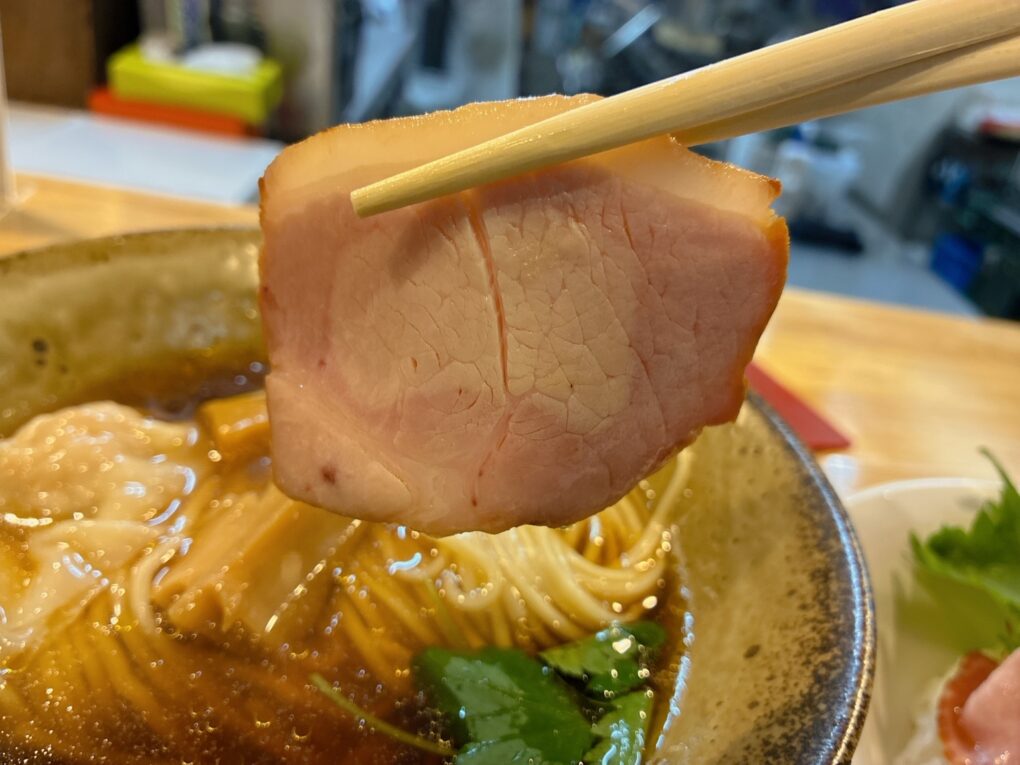 ラーメンにのったチャーシューを持ち上げたところ。