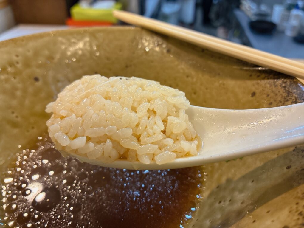 食事の終盤。ご飯をのせたレンゲを、スープの丼の上で撮影。