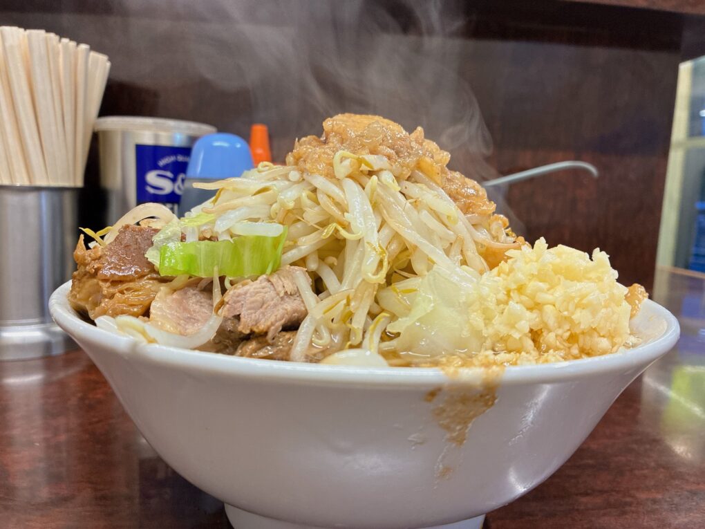 横から見たぶた小ラーメンと丼の縁を超えるヤサイの山